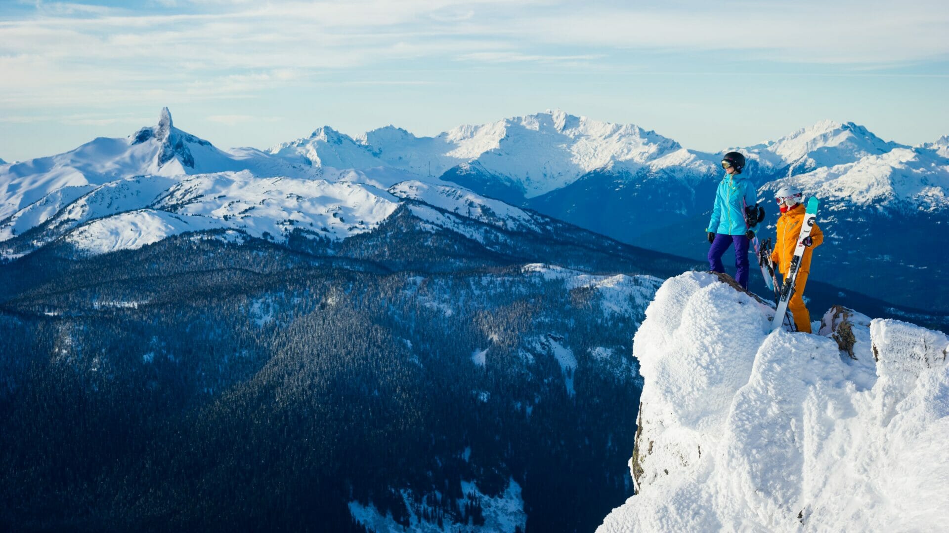Female skiers and rider checking out the stunning alpine views from Whistler peak