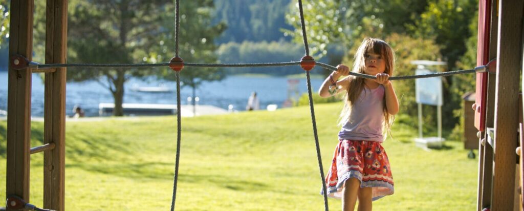 Child climbs on play structure at lakeside Park.