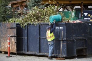 Man dumping yard waste into a bin
