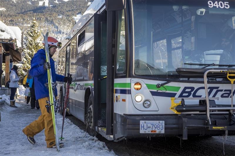 Person boarding a bus in ski gear in Whistler