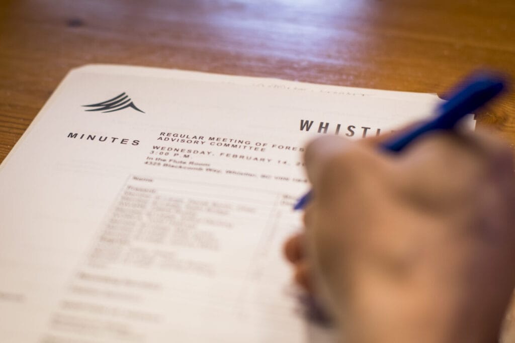 A person writes on an agenda during a Council meeting