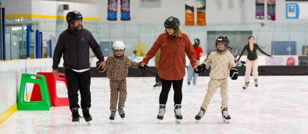 A family ice skating together indoors