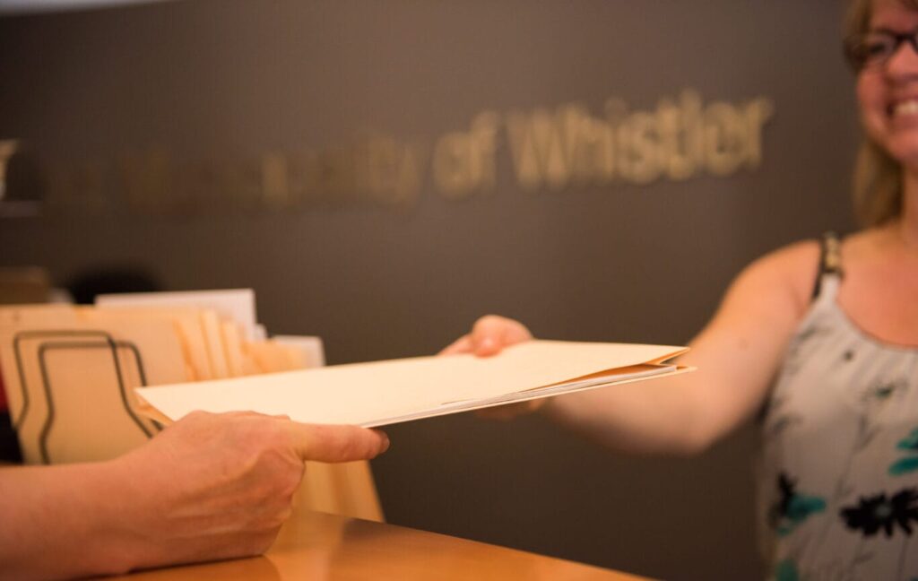 Woman handing a file folder over