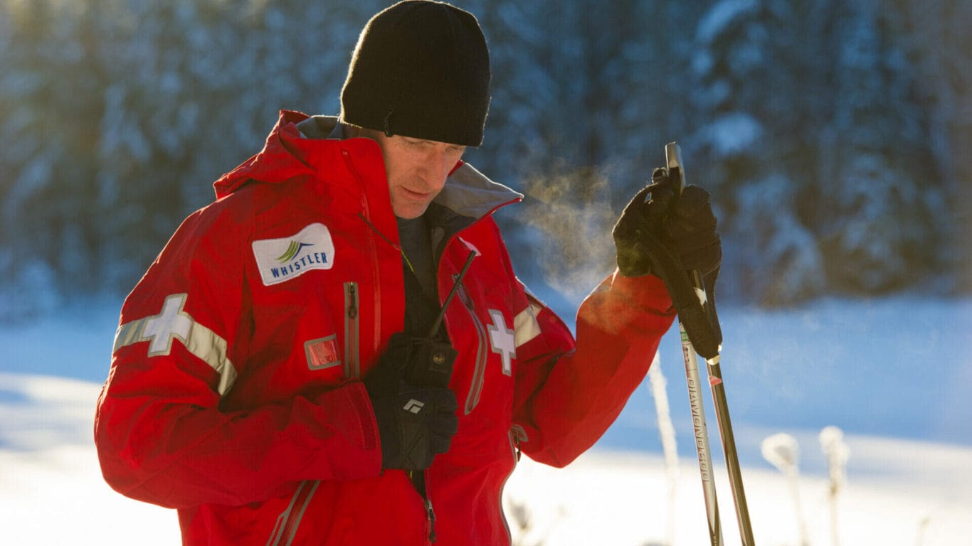 Nordic ski patroller checking his radio