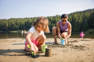 Mom and child playing in the sand at Lost Lake in Whistler, British Columbia