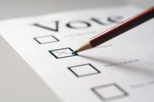 Close-up of a pencil marking a checkbox on a form, selecting an option