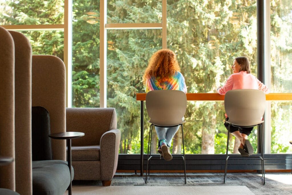 Two people sitting at a window in the Whistler Public Library.